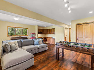 This spacious rec room is perfect for entertaining, featuring a comfortable sectional sofa and a classic foosball table.