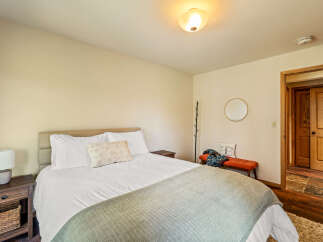 This cozy bedroom features a comfortable bed with soft linens and a stylish throw blanket, perfect for a relaxing retreat.