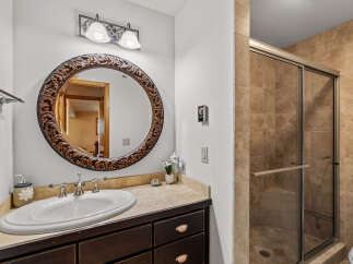 This stunning bathroom features a beautiful vanity with a large, ornate mirror, perfect for getting ready in style.
