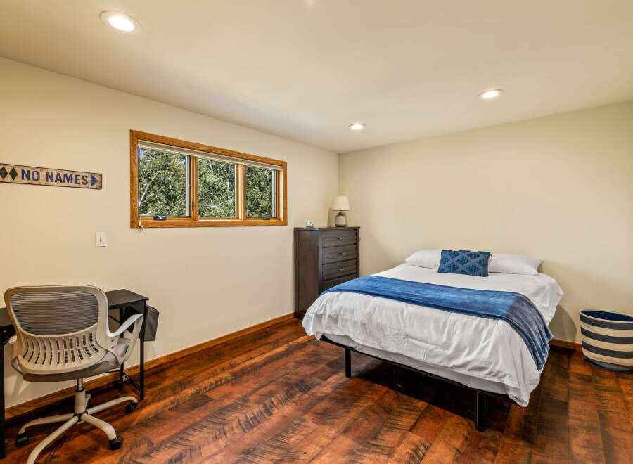 This cozy bedroom features a comfortable bed with a stylish blue throw and decorative pillow, perfect for relaxation.