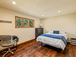 This cozy bedroom features a comfortable bed with a stylish blue throw and decorative pillow, perfect for relaxation.