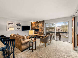 This stunning property features a cozy living room with a stone fireplace, perfect for relaxing evenings.