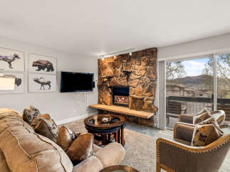 This cozy living room features a stunning stone fireplace, perfect for those chilly evenings.