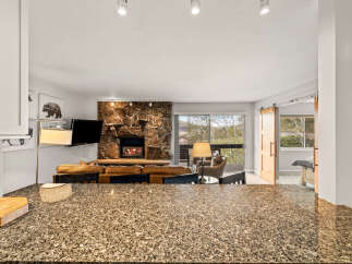 Step into luxury with this stunning property featuring a cozy fireplace and a modern kitchen.