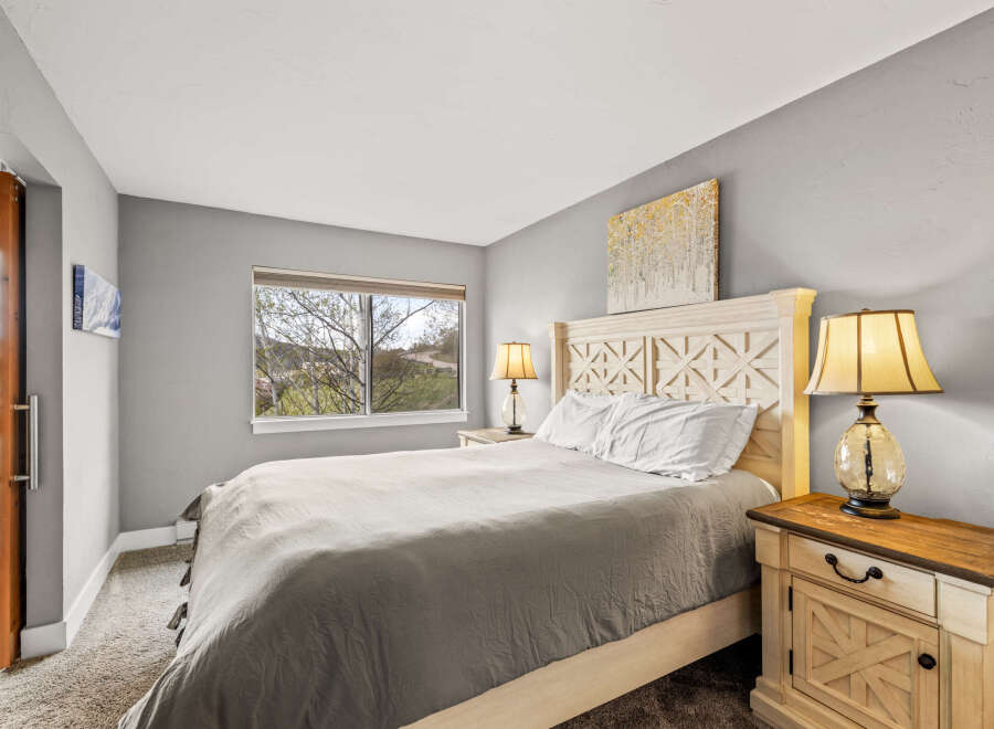 This cozy bedroom features a comfortable bed with a stylish headboard and a neutral color palette.