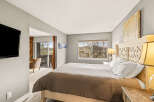 Step into this inviting bedroom, featuring a cozy bed and a serene ambiance.