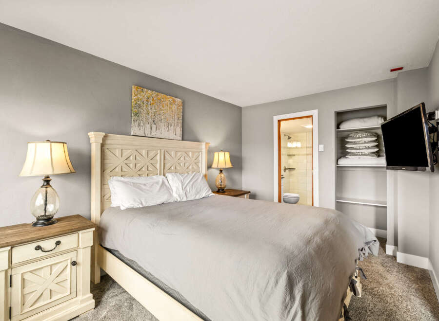This cozy bedroom features a comfortable bed with a stylish headboard, perfect for a relaxing retreat.