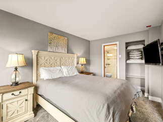 This cozy bedroom features a comfortable bed with a stylish headboard, perfect for a relaxing retreat.