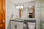This stunning bathroom features a modern vanity with a granite countertop and a sleek, undermount sink.