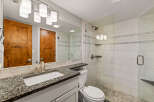 Step into this beautifully designed bathroom, featuring a sleek glass shower and a stylish vanity with a granite countertop.