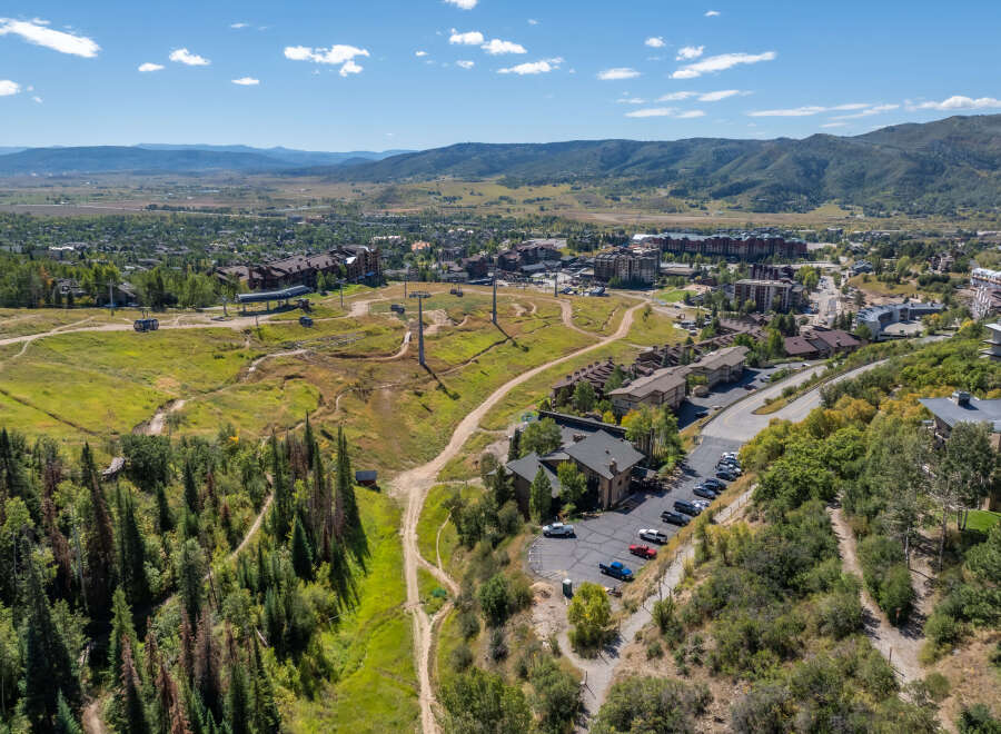 An aerial view showcases a stunning mountain resort town, perfect for a luxurious getaway.