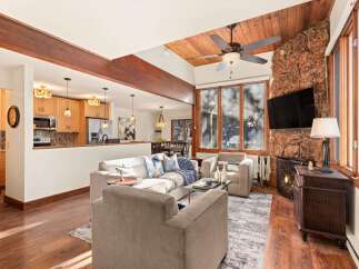 This stunning property boasts a cozy living room with a stone fireplace and a large flat-screen TV, perfect for relaxing evenings.