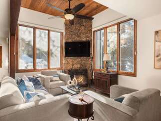 Step into luxury with this stunning living room, featuring a cozy fireplace and a sleek mounted TV.