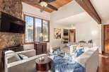 This stunning living room boasts a cozy ambiance with a stone fireplace and a beautiful wooden ceiling.