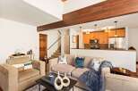 Step into this inviting living space, featuring a cozy seating area and a stylish open kitchen.