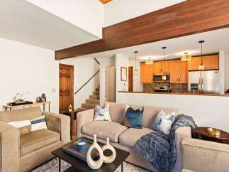 Step into this inviting living space, featuring a cozy seating area and a stylish open kitchen.