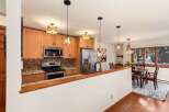 This stunning kitchen boasts beautiful wooden cabinetry, stainless steel appliances, and a stylish backsplash.