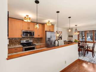 This stunning kitchen boasts beautiful wooden cabinetry, stainless steel appliances, and a stylish backsplash.
