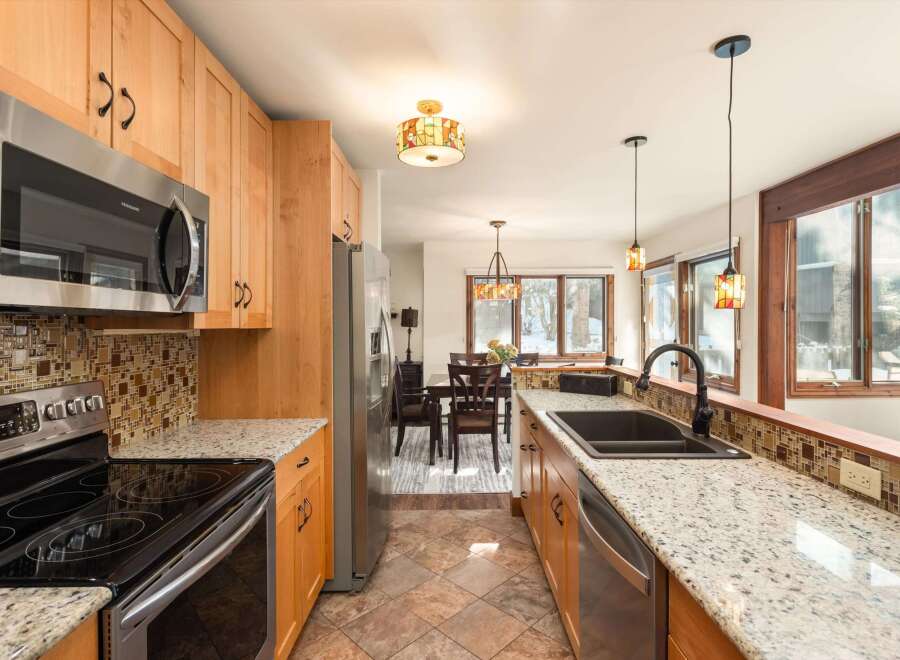 Step into this stunning kitchen, boasting beautiful wooden cabinetry and sleek stainless steel appliances.