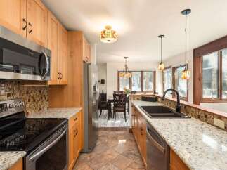 Step into this stunning kitchen, boasting beautiful wooden cabinetry and sleek stainless steel appliances.