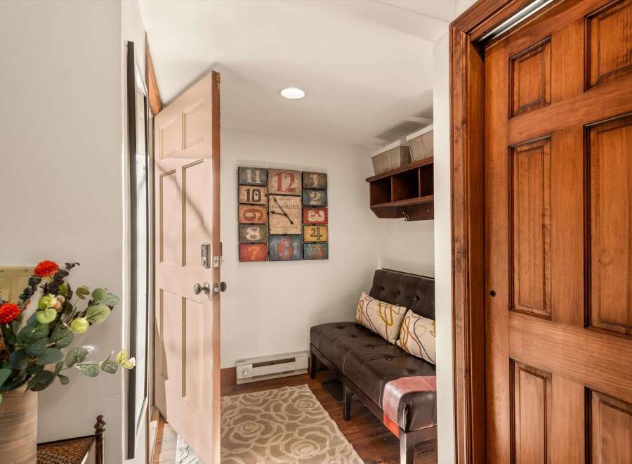 Step into this inviting entryway, showcasing a stylish bench and a unique clock.