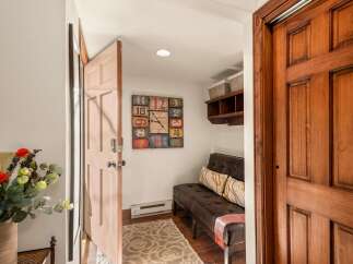 Step into this inviting entryway, showcasing a stylish bench and a unique clock.