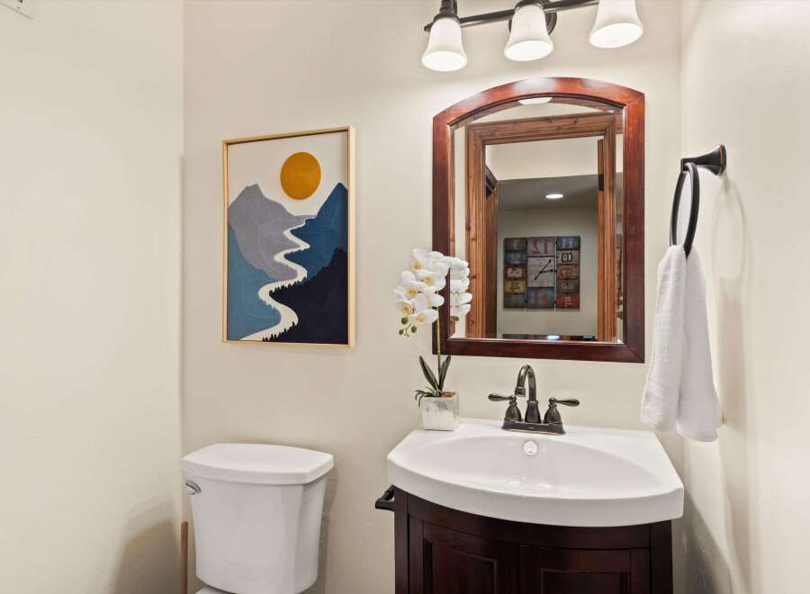 This charming bathroom features a stylish vanity with a sleek sink and a dark wood finish.