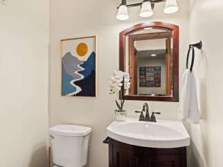 This charming bathroom features a stylish vanity with a sleek sink and a dark wood finish.