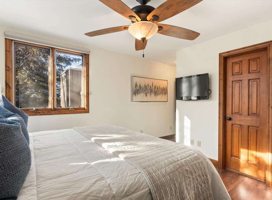 This inviting bedroom features a cozy ambiance with a comfortable bed and a stylish ceiling fan.