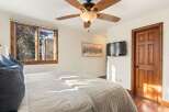 This inviting bedroom features a cozy ambiance with a comfortable bed and a stylish ceiling fan.