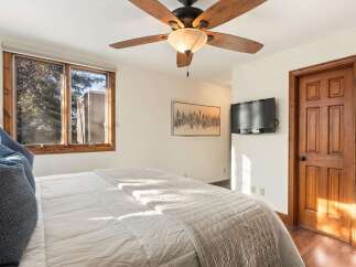 This inviting bedroom features a cozy ambiance with a comfortable bed and a stylish ceiling fan.