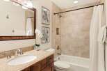 Step into a beautifully designed bathroom featuring a stylish vanity with a granite countertop and a sleek sink.