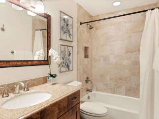 Step into a beautifully designed bathroom featuring a stylish vanity with a granite countertop and a sleek sink.