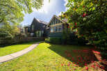 This stunning property boasts a beautifully landscaped front yard with a winding pathway leading to the entrance.