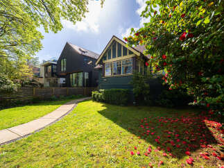 This stunning property boasts a beautifully landscaped front yard with a winding pathway leading to the entrance.