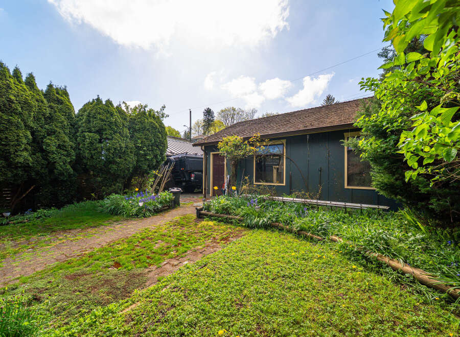 Discover the charm of this unique property, featuring a cozy home with a rustic exterior and lush landscaping.