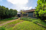 Discover the charm of this unique property, featuring a cozy home with a rustic exterior and lush landscaping.
