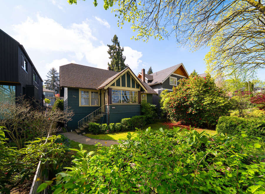 Charming craftsman-style home with a welcoming facade and lush landscaping.