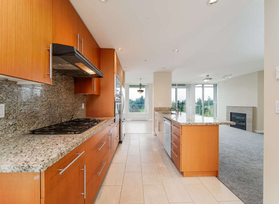 Step into this stunning kitchen, featuring sleek wooden cabinetry and elegant granite countertops.