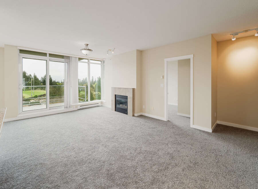 Step into luxury with this stunning living space, featuring a cozy fireplace and expansive windows that flood the room with natural light.