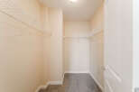 Step into this spacious walk-in closet, offering ample storage with its built-in shelving.