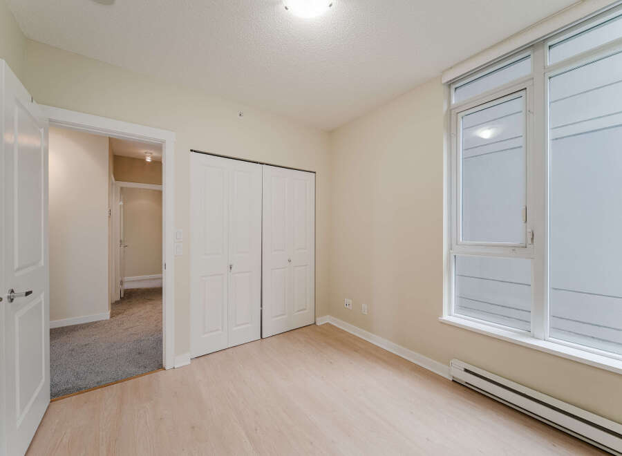 Step into this bright and airy bedroom, featuring a large window that floods the space with natural light.