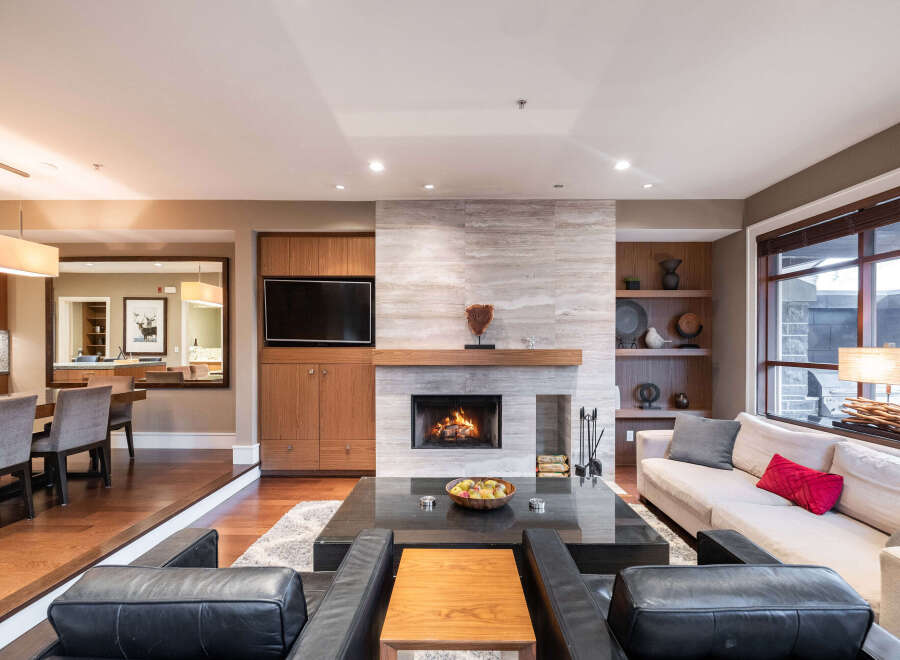 Experience luxury living in this stunning property, featuring a cozy fireplace and a modern entertainment center.