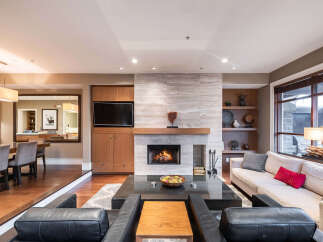 Experience luxury living in this stunning property, featuring a cozy fireplace and a modern entertainment center.
