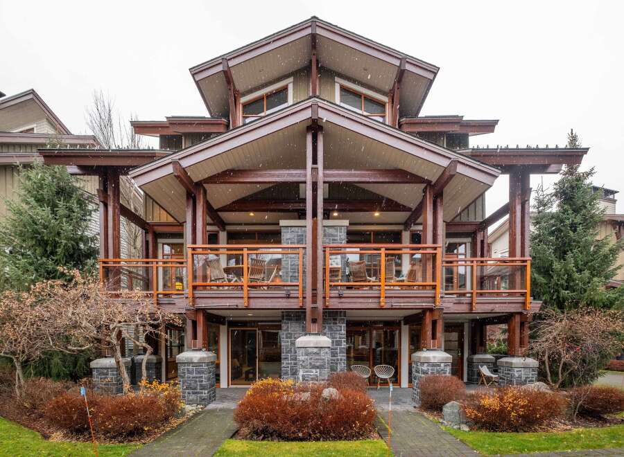 This stunning property boasts a unique architectural design with exposed wooden beams and multiple levels of balconies.