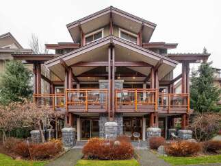 This stunning property boasts a unique architectural design with exposed wooden beams and multiple levels of balconies.