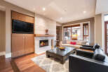 Experience luxury living in this stunning property, featuring a cozy living room with a fireplace and a modern entertainment center.