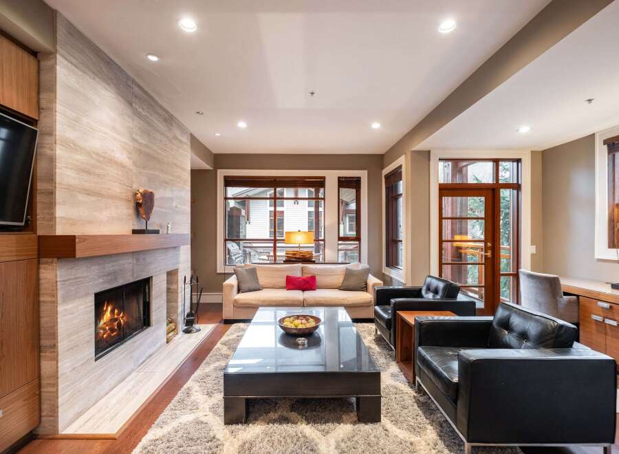 Experience luxury living in this stunning property, featuring a cozy fireplace and a modern entertainment setup.