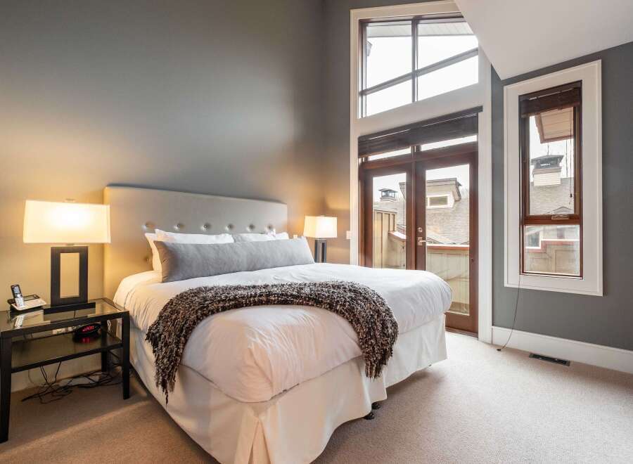 This luxurious bedroom boasts a serene ambiance with its neutral color palette and ample natural light.