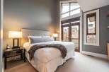 This luxurious bedroom boasts a serene ambiance with its neutral color palette and ample natural light.